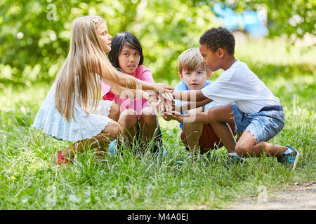 Multikulturelle Gruppe von Kindern ist das Stapeln die Hände als Zeichen der Freundschaft Stockfoto