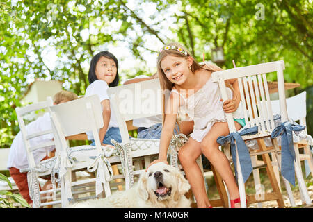 Mädchen Streicheln ein Golden Retriever im Garden Party im Sommer Stockfoto