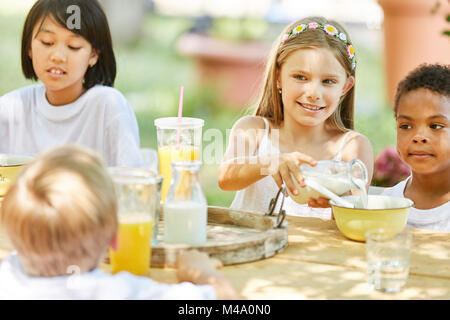 Multikulturelle Gruppe von Kindern Frühstück zusammen mit Sommer Camp Stockfoto