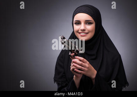 Die muslimische Frau im schwarzen Kleid vor einem dunklen Hintergrund Stockfoto