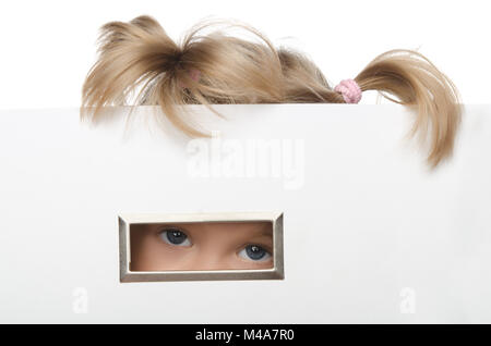 Kleines Mädchen schaut vorwitzig aus der Box Stockfoto