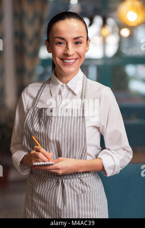 Junge ehrgeizige Kellnerin, um Stockfoto