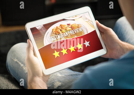 Gutes Restaurant. Zufriedene und glückliche Kunden, die große Bewertung mit Tablet-PC auf einer imaginären Kritik Website, Anwendung oder Website. Stockfoto