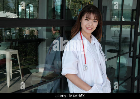 Selbstbewussten jungen Ärztin lächelte Kamera. Portrait von asiatischen medizinischen Personal, Arzt oder Arzt im Krankenhaus Stockfoto