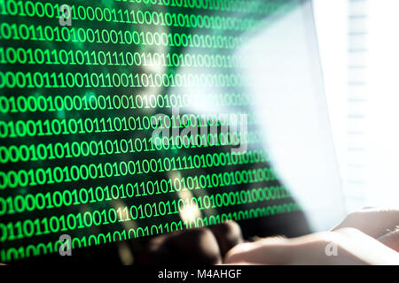 Hacker das Schreiben von Code mit Laptop. Binäre Zahlen, Null und Eins auf Monitor. Cyber Bedrohung, Angriff und online Kriminalität Konzept. Stockfoto