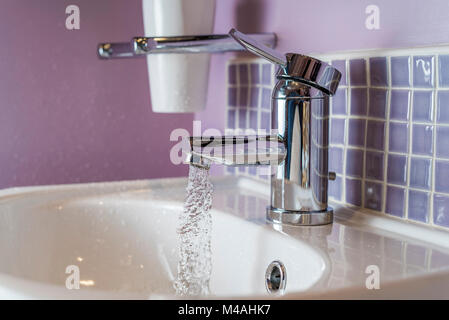 Wasser läuft aus einem Bad tippen oder Wasserhahn, in ein Waschbecken. Stockfoto