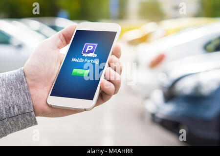 Mobile Parkplatz App auf dem Smartphone angezeigt. Mann, smart phone mit Parkplatz Anwendung in der Hand. Internet Payment online mit modernen Gerät. Stockfoto