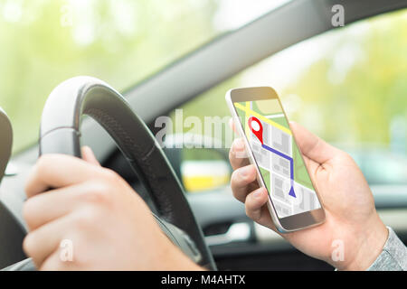 Man Autofahren und mithilfe von Karte und GPS-Anwendung auf mit Smart Phone. Navigation mit mobilen App. Innenansicht im Auto. Stockfoto