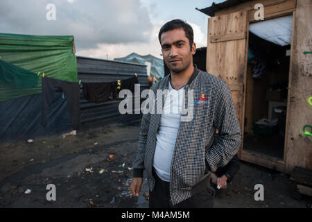 Afgan Mann an der Tür seines Hauses in die Dschungel von Calais. Die Recente News über die bevorstehende Zerlegen der Lager führen viele Zweifel über ihre Zukunft zu den Menschen hier. Stockfoto