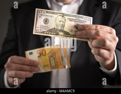 Dollar gegen Euro. Business Mann in Anzug 50 Banknoten- und Bill sowohl in der Währung in der Hand. Wechselkurs, Weltwirtschaft und das Finanzkonzept. Stockfoto