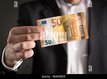 Business Mann in Anzug halten Sie die neue 50-Euro-Banknote und Bill. Stockfoto