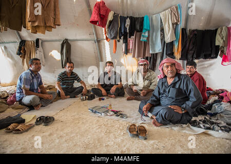 Eine Gruppe von syrischen Flüchtlingen Männern in einem Zelt in der Suruç Camp in der Türkei sitzen in der Nähe der syrischen Grenze. Stockfoto