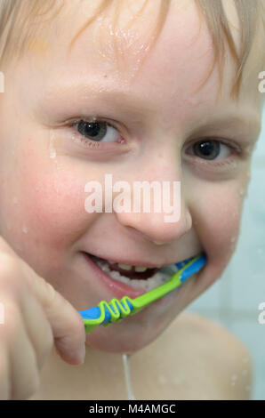 Ein teenager Boy in der Dusche ist seine Zähne putzen Stockfoto