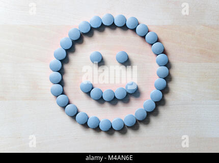 Smiley von Pillen auf Holztisch. Glücklich und positives Gefühl aus der erfolgreichen Heilungsprozess oder Gesundheitsversorgung und Arzt Dienstleistungen zufrieden. Stockfoto