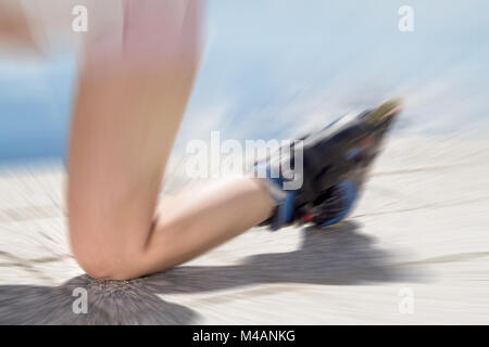 Junge Frau auf Rollschuhen fallen auf den Boden, Asphalt und Straße Knie zuerst. Inline- und rollerskates Unfall. Schmerzhafte Verletzungen zu Bein. Stockfoto