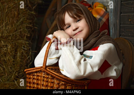 Schöne Mädchen in russische Tracht sitzt in einem traditionellen Interieur Stockfoto