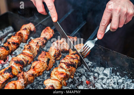 Gegrilltes kebab Kochen auf Metall Spieß. Gebratenes Fleisch am Grill zubereitet. Traditionelle östliche Teller, Shish Kebab. Holzkohle Grill und Flammen, Picknick, Street Food Stockfoto