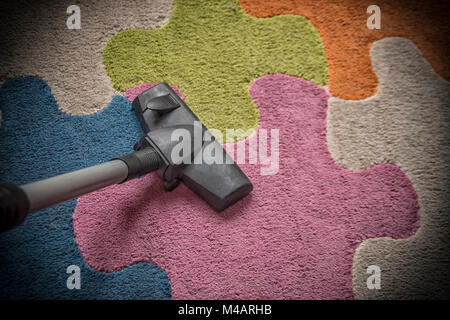 Ein Staubsauger auf einem bunten Teppich Stockfoto
