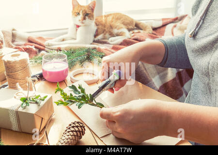 Frau Verpackung eco Weihnachten Geschenke auf hölzernen Tisch Stockfoto