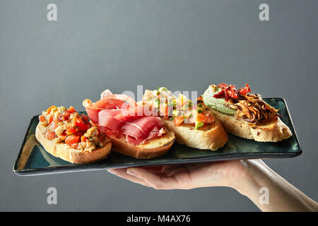 Köstliche italienische Bruschetta auf einem keramischen Fach Stockfoto