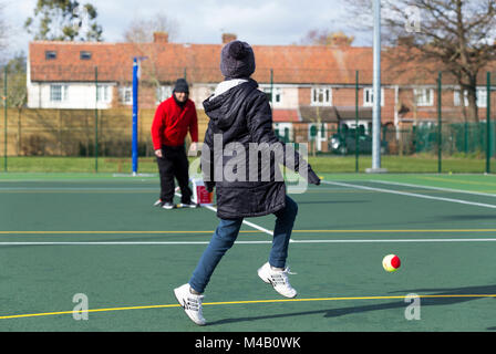 Kinder tennis Coaching/Lektion statt auf einen Tennisplatz mit Kindern/Kindern und professionellen Tennistrainer, im Winter. UK (94 Stockfoto