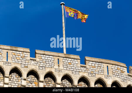 Die Royal Standard Flagge auf/von einem Fahnenmast/Pol im Schloss Windsor, UK. Es ist an der königlichen Residenzen geflogen, nur wenn die souveräne vorhanden ist. Stockfoto