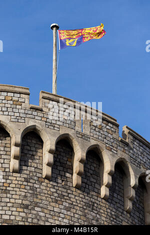 Die Royal Standard Flagge auf/von einem Fahnenmast/Pol im Schloss Windsor, UK. Es ist an der königlichen Residenzen geflogen, nur wenn die souveräne vorhanden ist. Stockfoto