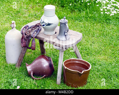Nostalgische Krüge und Schiffe auf alten Hocker Stockfoto