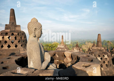 Buddha Bild mit der Hand, die Position des Dharmachakra Mudra, die drehen das Rad des Dharma. Borobudur buddhistischen Tempel, Java, Indonesien. Stockfoto