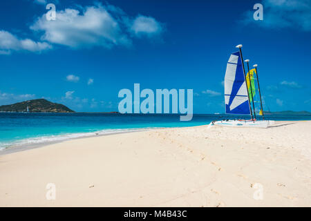 Katamarane an einem wunderschönen weißen Sandstrand auf Palm Island, Grenadinen Inseln, St. Vincent und die Grenadinen, Karibik Stockfoto