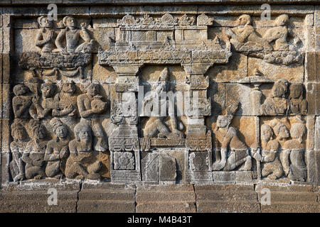 Reliefs auf einen Korridor an der Wand. Borobudur buddhistischen Tempel, Magelang Regency, Java, Indonesien. Stockfoto