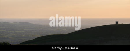 Spaziergang mit dem Hund auf einem verschneiten Winter Hill Road mit Fiddlers Ferry Kraftwerks im Abstand Stockfoto