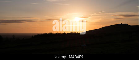 Am späten Abend Foto aus dem Winter Hill mit Blick auf Rivington Pike Silhouette gegen das warme Glühen des Abends, Sommer Sonne Stockfoto