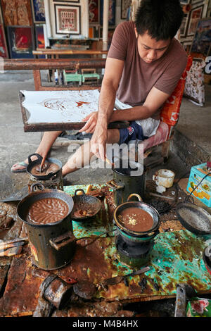 Ein Batikmacher arbeitet in seiner Werkstatt bei Batik Seno, einer Galerie in Yogyakarta, Java, Indonesien. Stockfoto