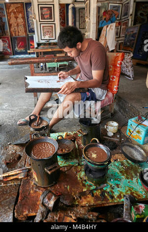 Ein Batikmacher arbeitet in seiner Werkstatt bei Batik Seno, einer Galerie in Yogyakarta, Java, Indonesien. Stockfoto