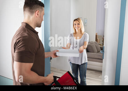Freundlich Delivery Man Übergabe Pizza glückliche junge Frau Stockfoto