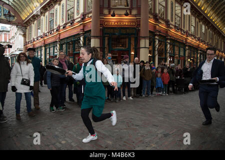 Faschingsdienstag Festlichkeiten als Konkurrenten richten für den Pancake Day Rennen Leadenhall Market am 13. Februar 2018 in London, Vereinigtes Königreich. Konkurrierende Mannschaften der Stadt Mitarbeiter außerhalb des Lammes Taverne gegen die 25-m-Kurs, im Wettbewerb um den begehrten Pfanne Trophäe als Sie Flip ihren Weg rund um die historischen des 14. Jahrhunderts. Stockfoto