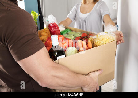 Nahaufnahme einer Lieferung Mann, Lebensmittelgeschäft Karton Frau Stockfoto