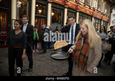 Faschingsdienstag Festlichkeiten als Konkurrenten richten für den Pancake Day Rennen Leadenhall Market am 13. Februar 2018 in London, Vereinigtes Königreich. Konkurrierende Mannschaften der Stadt Mitarbeiter außerhalb des Lammes Taverne gegen die 25-m-Kurs, im Wettbewerb um den begehrten Pfanne Trophäe als Sie Flip ihren Weg rund um die historischen des 14. Jahrhunderts. Stockfoto