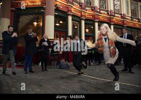 Faschingsdienstag Festlichkeiten als Konkurrenten richten für den Pancake Day Rennen Leadenhall Market am 13. Februar 2018 in London, Vereinigtes Königreich. Konkurrierende Mannschaften der Stadt Mitarbeiter außerhalb des Lammes Taverne gegen die 25-m-Kurs, im Wettbewerb um den begehrten Pfanne Trophäe als Sie Flip ihren Weg rund um die historischen des 14. Jahrhunderts. Stockfoto