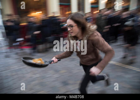 Faschingsdienstag Festlichkeiten als Konkurrenten richten für den Pancake Day Rennen Leadenhall Market am 13. Februar 2018 in London, Vereinigtes Königreich. Konkurrierende Mannschaften der Stadt Mitarbeiter außerhalb des Lammes Taverne gegen die 25-m-Kurs, im Wettbewerb um den begehrten Pfanne Trophäe als Sie Flip ihren Weg rund um die historischen des 14. Jahrhunderts. Stockfoto