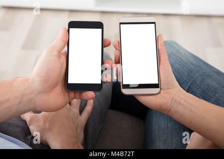 In der Nähe von ein Paar hält Handy Mit Leerer weißer Bildschirm Stockfoto