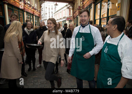 Faschingsdienstag Festlichkeiten als Konkurrenten richten für den Pancake Day Rennen Leadenhall Market am 13. Februar 2018 in London, Vereinigtes Königreich. Konkurrierende Mannschaften der Stadt Mitarbeiter außerhalb des Lammes Taverne gegen die 25-m-Kurs, im Wettbewerb um den begehrten Pfanne Trophäe als Sie Flip ihren Weg rund um die historischen des 14. Jahrhunderts. Stockfoto