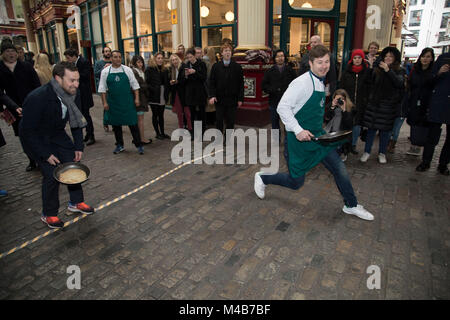 Faschingsdienstag Festlichkeiten als Konkurrenten richten für den Pancake Day Rennen Leadenhall Market am 13. Februar 2018 in London, Vereinigtes Königreich. Konkurrierende Mannschaften der Stadt Mitarbeiter außerhalb des Lammes Taverne gegen die 25-m-Kurs, im Wettbewerb um den begehrten Pfanne Trophäe als Sie Flip ihren Weg rund um die historischen des 14. Jahrhunderts. Stockfoto