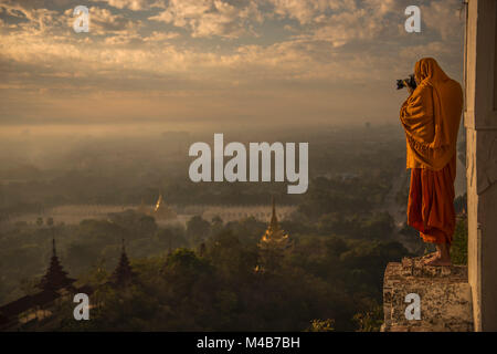 Buddhistischer Mönch, der die Wahrzeichen des buddhistischen Tempels im Sunrise Valley von Bagan fotografiert Stockfoto