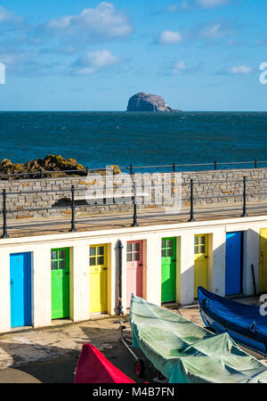 North Berwick Yacht Club überdachte Boote im Hafen und bunten Reihe von Türen. Bass Rock und Leuchtturm am Horizont, Schottland, Großbritannien Stockfoto