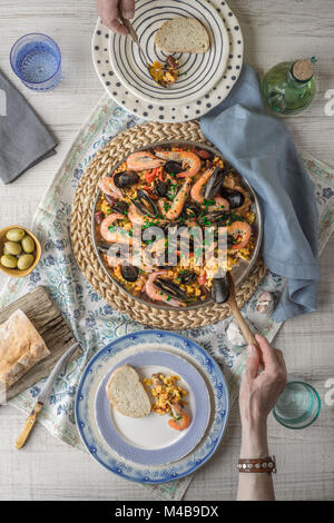 Essen Paella auf dem Tisch mit schönen Serviette Draufsicht Stockfoto