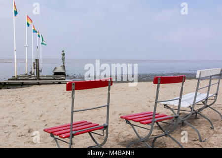 Stühle am Strand von Dangast mit Blick auf das Wattenmeer und Kunstwerk Stockfoto