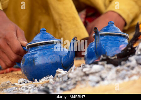 Algerien. In der Nähe von Djanet. Sahara. Mann, der Stamm der Tuareg Tee. Teekannen Erwärmung in Brand. Close-up Teekannen. Nomad. Stockfoto