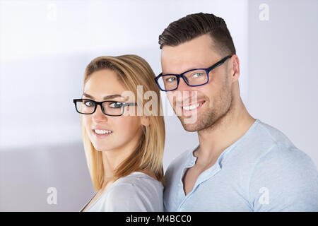 Foto von glückliches junges Paar mit stilvollen Brillen Stockfoto